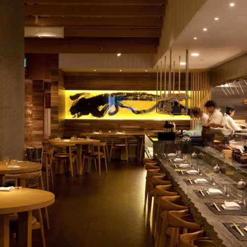 Restaurant interior with crafted timber tables, counter seating and warm lighting